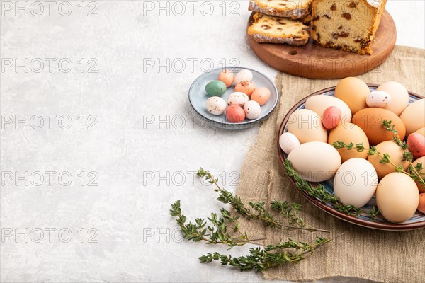Homemade easter pie with raisins and eggs on plate on a gray concrete background and linen textile. side view, copy space