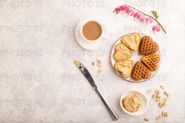 Homemade waffle with peanut butter and cup of coffee on a gray concrete background. top view, flat lay, copy space