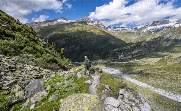 Mountaineers on a hiking trail in front of a picturesque mountain landscape, rocky mountain peaks with snow, valley Zemmgrund with Zemmbach, mountain panorama with summit Zsigmondyspitze and Grosser Moerchner, Berliner Hoehenweg, Zillertal Alps, Tyrol, Austria, Europe