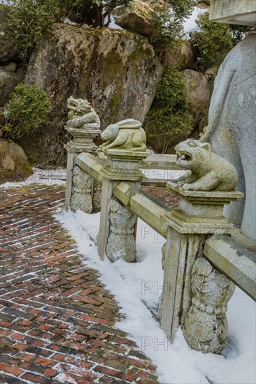 Stone carved dragon, rabbit and bear that represents the Chinese horoscope, on concrete fence in South Korea