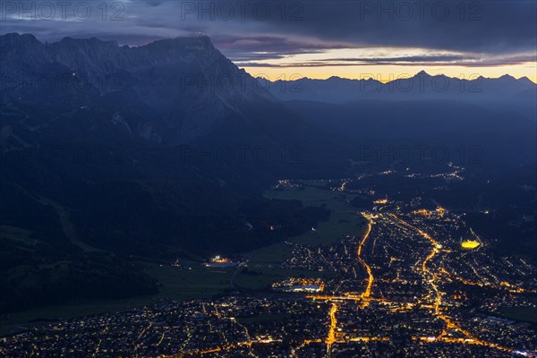 Town at night with lights in front of mountains, Garmisch-Partenkirchen, left Zugspitze, Wetterstein range, Upper Bavaria, Bavaria, Germany, Europe