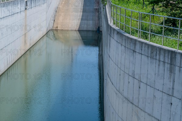 Pool of placid water at bottom of concrete spillway