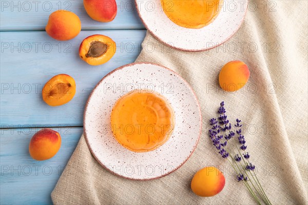 Apricot orange jelly on blue wooden background and linen textile. top view, flat lay, close up