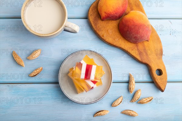 Almond milk and peach jelly on blue wooden background. top view, flat lay, close up