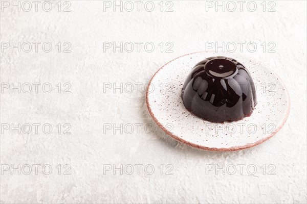 Black currant and grapes jelly on gray concrete background. side view, copy space