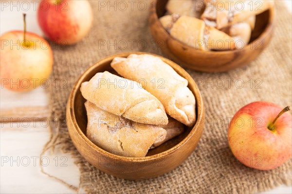 Homemade sweet cookie with apple jam and cup of coffee on white wooden background and linen textile. side view, close up, selective focus