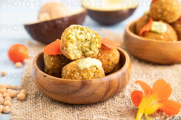 Falafel with guacamole on blue wooden background and linen textile. Side view, close up, selective focus