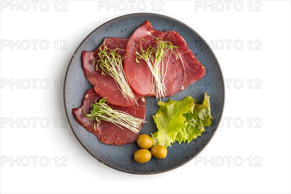 Slices of smoked salted meat with cilantro microgreen isolated on white background. Top view, flat lay, close up