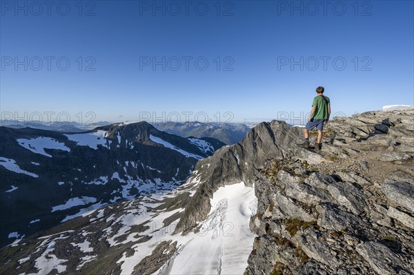 Mountain panorama, glacier remains of Skalabreen, mountaineer at the summit of Skala, Loen, Norway, Europe