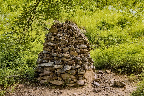 Column of stones and pebble stacks beside hiking trail in recreational forest in South Korea