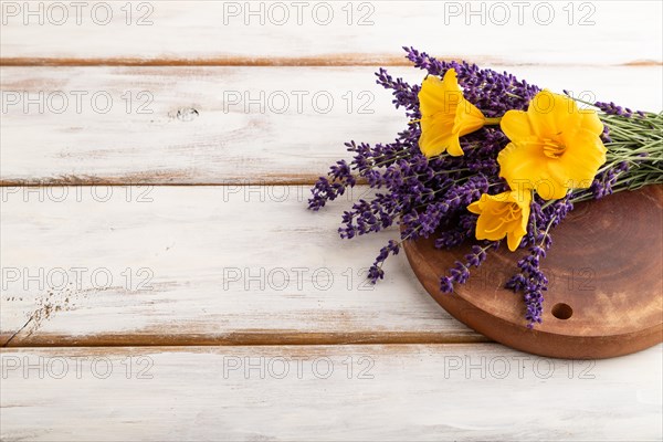 Beautiful day lily and lavender flowers on white wooden background, side view, copy space