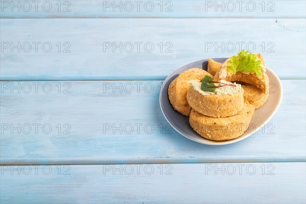 Homemade salted crescent-shaped cheese cookies, on blue wooden background. side view, copy space