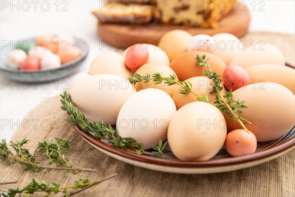 Homemade easter colored eggs on plate and raisins cake on a gray concrete background and linen textile. side view, close up, selective focus