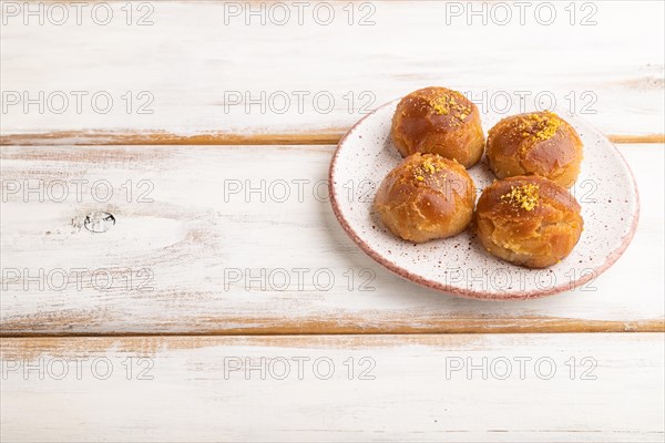 Homemade traditional turkish dessert sekerpare with almonds and honey on white wooden background. side view, copy space