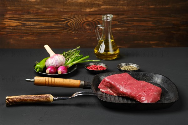 Raw juicy top round beef steak on grill pan
