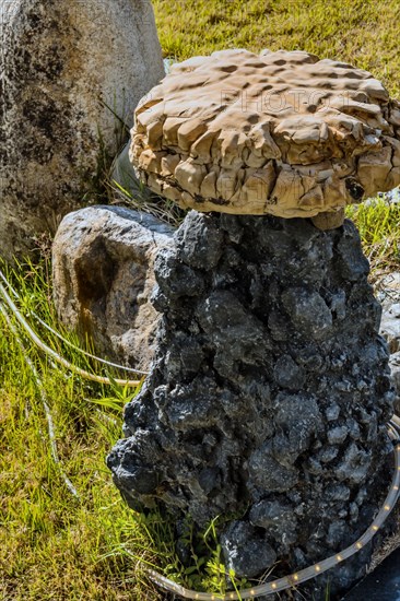 Large round flat stone placed on top of black granite stone in public geological park in Gimcheon, South Korea, Asia