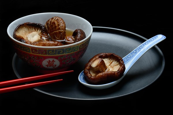 Dried shiitake mushrooms in a bowl, soaked in water