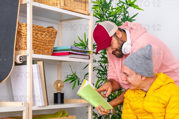 Man helping to read a book to a disabled man at home