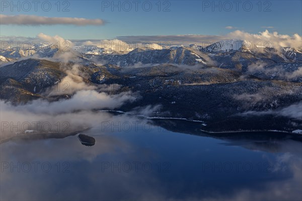 Distant view over mountain lake in the evening light, snow-covered mountains, clouds and fog, winter, view from Herzogstand to Walchensee, Bavarian Alps, Upper Bavaria, Bavaria, Germany, Europe