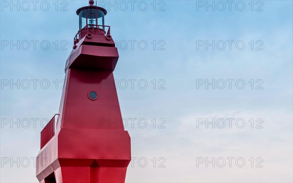 Closeup of red lighthouse built in shape of horse on concrete pier in Jeju, South Korea, Asia