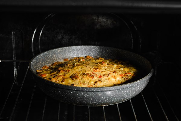 Mushroom pie with chicken meat on grid in oven