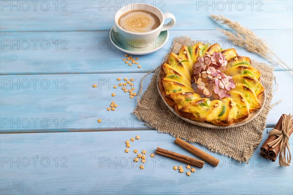 Cheesecake with cup of coffee on blue wooden background and linen textile. side view, copy space