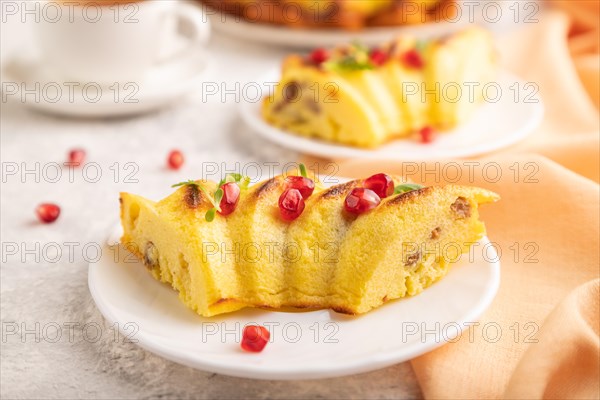 Cheesecake with cup of green tea on gray concrete background and orange linen textile. side view, close up, selective focus