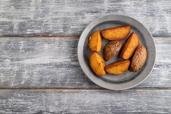 Heap of fried potato on a gray plate on a gray wooden background. Top view, flat lay, close up, copy space