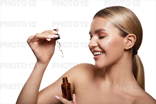 Beauty portrait of model with natural make-up holding a jar of cream. Fashion shiny highlighter on skin, sexy gloss lips make-up High quality photo. Holds face care cosmetics