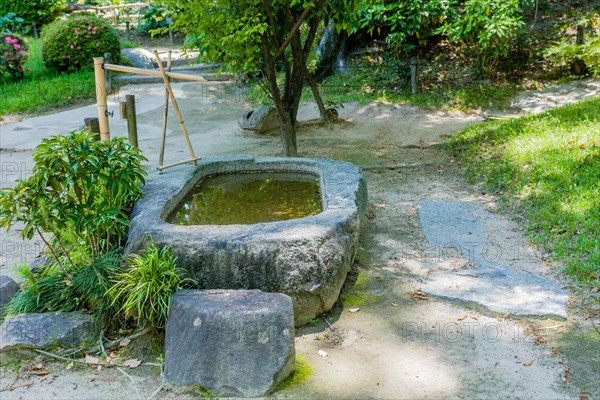 Stone water basin with bamboo pluming in Japanese garden in Hiroshima, Japan, Asia