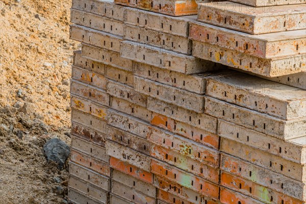 Closeup of concrete forms stacked on ground of new construction site