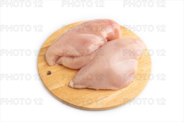Raw chicken breast on a wooden cutting board isolated on white background. Side view, close up