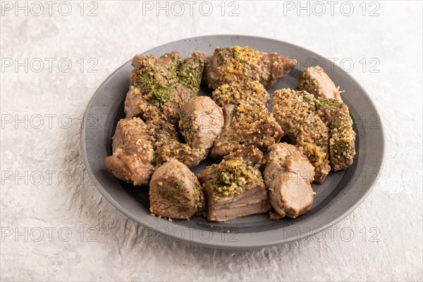 Stewed turkey fillet with garlic on gray concrete background. Side view, close up