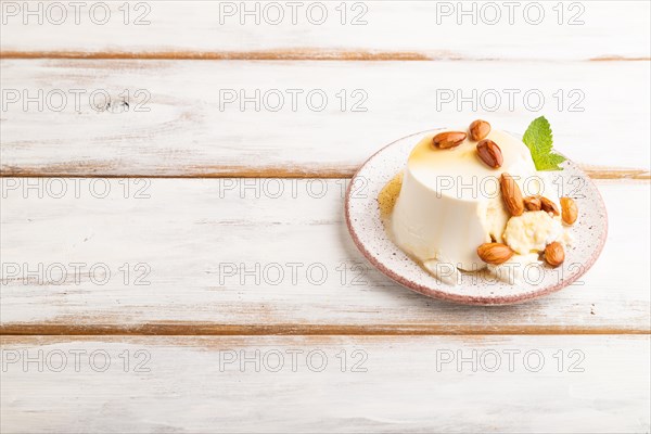 Ricotta cheese with honey and almonds on white wooden background. side view, copy space