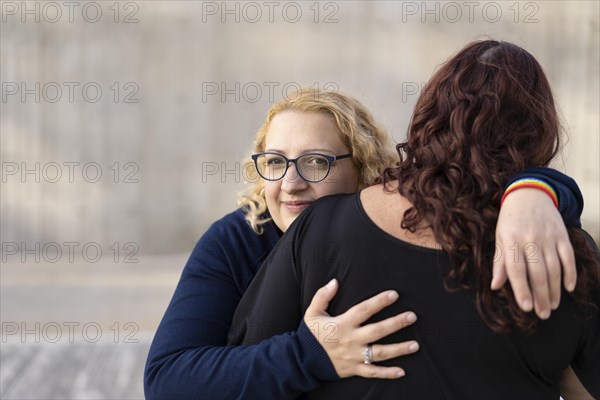 Two women hugging in the park with serious attitude