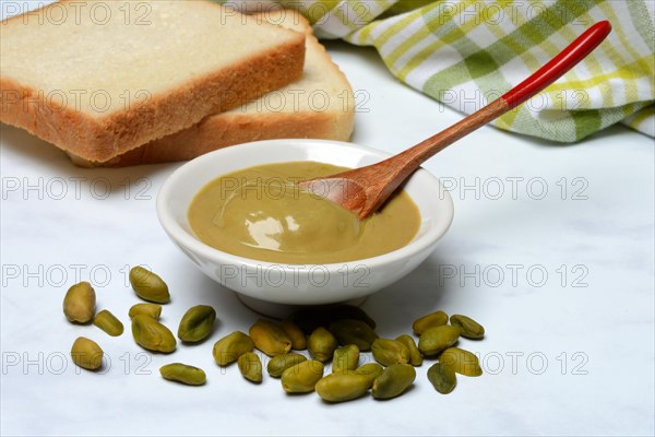 Pistachio cream in small bowls and slices of bread, pistachio