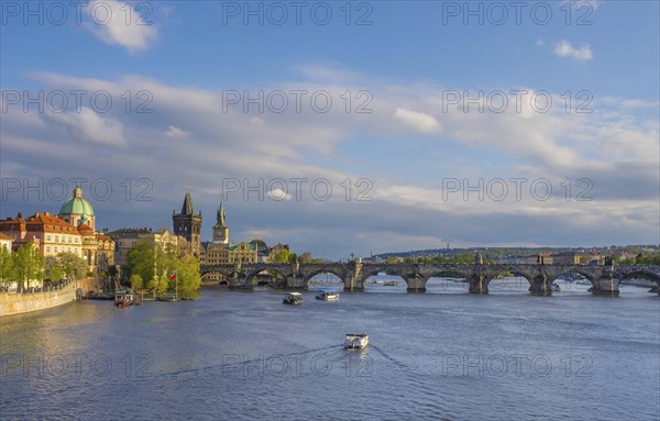 Charles Bridge (Karluv Most) on Vltava river and Old Town Bridge Tower, famous tourist destination in Prague, Czech Republic (Czechia), at sunset