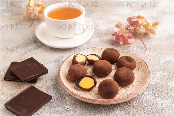 Japanese rice sweet buns chocolate mochi filled with cream and cup of green tea on brown concrete background. side view, close up