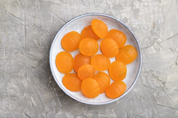 Jelly pumpkin candies on gray concrete background. close up, top view, flat lay. autumn concept