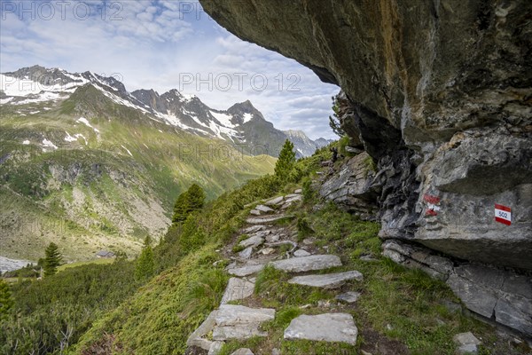 Hiking trail under a rocky outcrop in a picturesque mountain landscape, Berliner Hoehenweg, Zillertal Alps, Tyrol, Austria, Europe