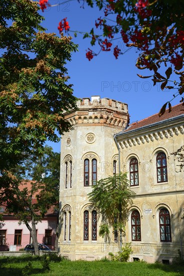 Historic building with battlements under a clear blue sky, surrounded by nature and blooming flowers, Officers' Palace, Komarno, Komarom, Komorn, Nitriansky kraj, Slovakia, Europe