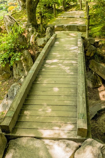 Shaded wooden footbridge in Japanese Shukkeien Gardens in Hiroshima, Japan, Asia