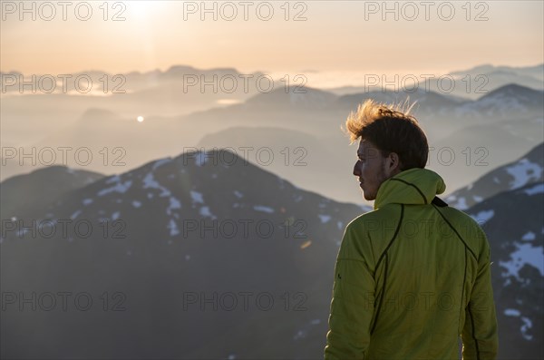 Mountaineer enjoying the view, mountain panorama at the summit of Skala at sunset, Loen, Norway, Europe