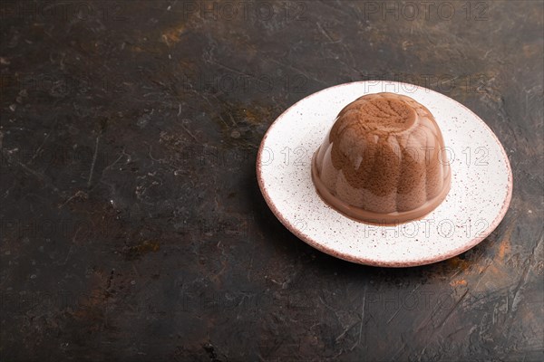 Chocolate jelly on black concrete background. side view, copy space