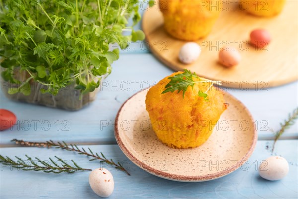 Homemade cakes with chocolate eggs and mizuna cabbage microgreen on a blue wooden background. side view, close up, selective focus