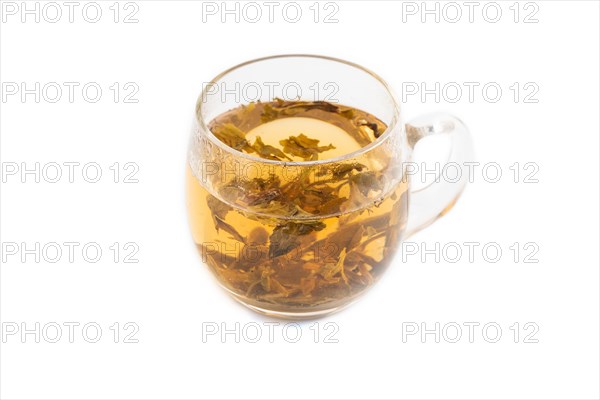 Red tea with herbs in glass cup isolated on white background. Healthy drink concept. Side view, close up