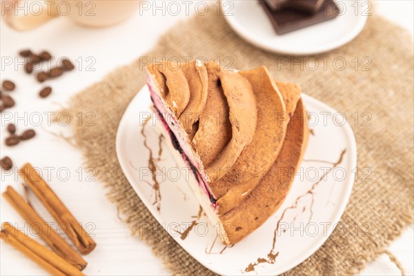 Zephyr or marshmallow cake with cup of coffee on white wooden background and linen textile. side view, close up, selective focus