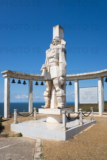Monumental statue under a clear blue sky with a memorial plaque and bells, Memorial to Admiral Ushakov, Cape Kaliakra, Dobruja, Black Sea, Bulgaria, Europe