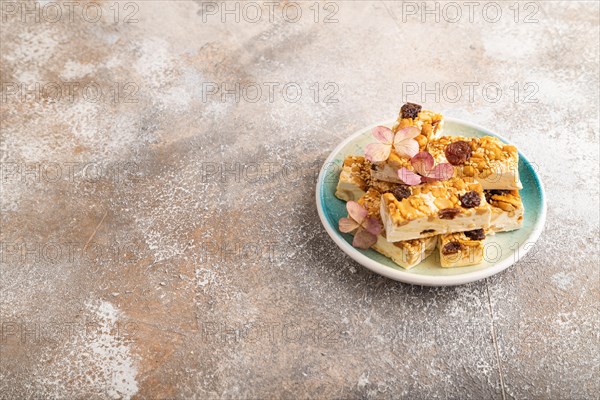 Traditional candy nougat with nuts and sesame on brown concrete background. side view, copy space