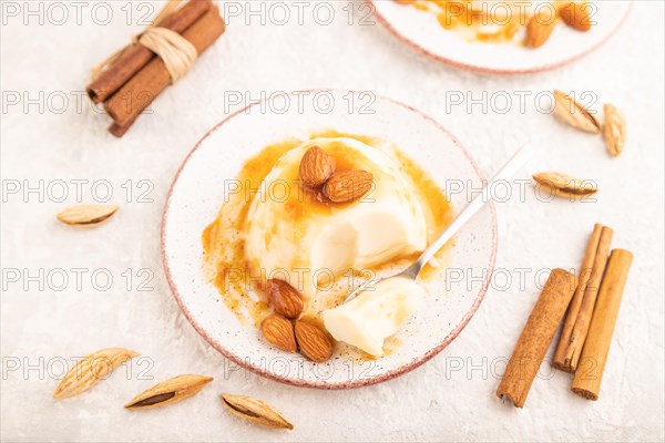 White milk jelly with caramel sauce on gray concrete background. side view, close up, selective focus